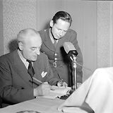 Ernst Haeusserman in der Uniform eines US-Cultural Officer rechts hinten neben Raoul Aslan am 11.4.1946 vor einem Mikrophon des Rundfunksenders Radio 'Rot-Weiß-Rot' (Foto der United States Information Services)