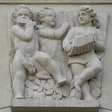 Oskar Thiede, Musizierende Kinder, Schlussstein (1951/52). Gemeindebau ‚Hugo-Breitner-Hof‘, Linzerstraße 317–319 (Wien XIV)