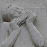 Robert Ullmann, Mundharmonika spielender Knabe, Steinrelief (1966, Wohnhaus-Wiederaufbaufonds). Ketzergasse 23 (Wien XXIII)
