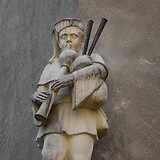 Theodor Igler, Sackpfeifer (Lieber Augustin?), Natursteinplastik (1953/54). Gemeindebau Erlachgasse 53–57 (Wien X)