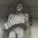 Oskar Thiede (?), Ziehharmonikaspieler als Fassadenskulptur am Gemeindebau ‚Goethehof‘ (vor 1932). Schüttaustraße 1–39 (Wien XXII)